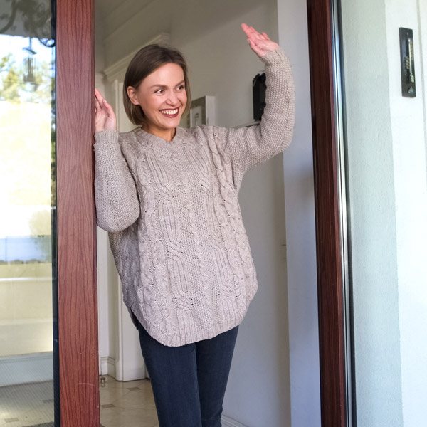 neighbor waving while standing at her door